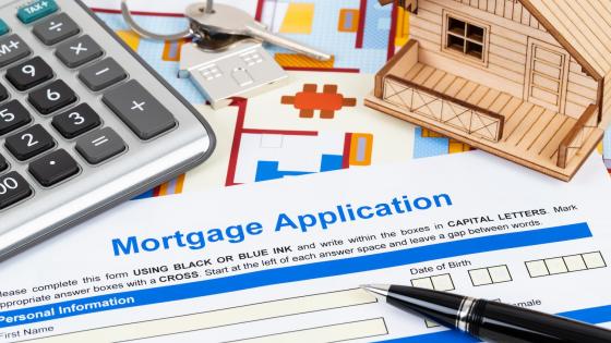 Mortgage application form, calculator and wooden model house