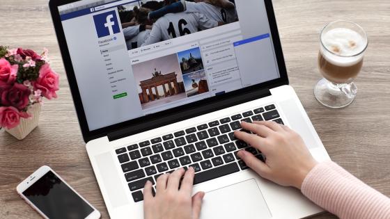 Person using Facebook on laptop